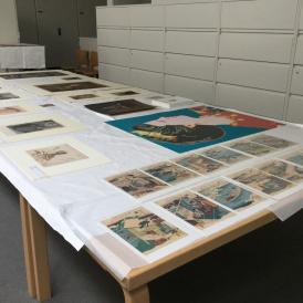 Art laid out for a Five Tables viewing at BAMPFA